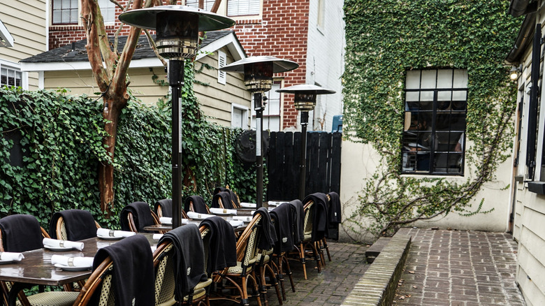 Tables and chairs in the outdoor dining area of Chez Nous, Charleston