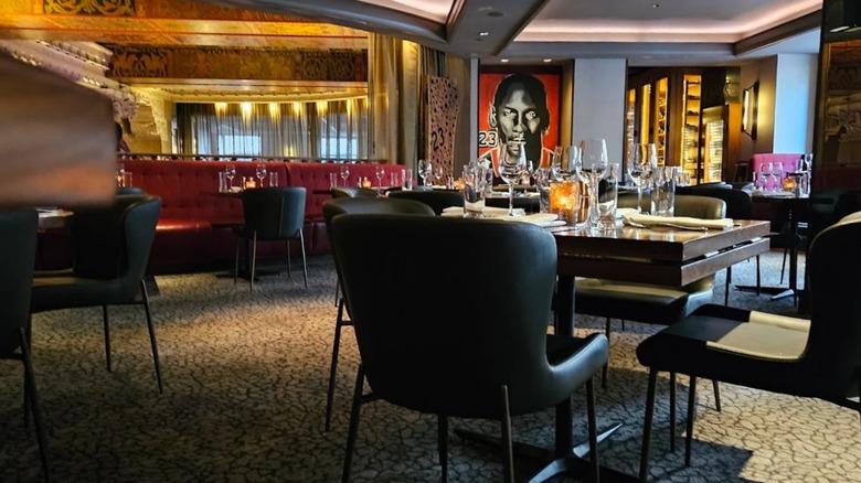 The interior of Michael Jordan's Steak House with chairs and tables and Michael Jordan's portrait in the background