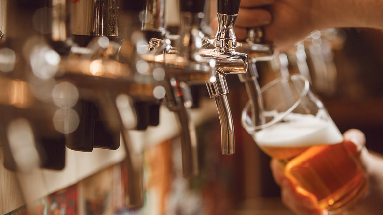 Someone pouring a draft beer