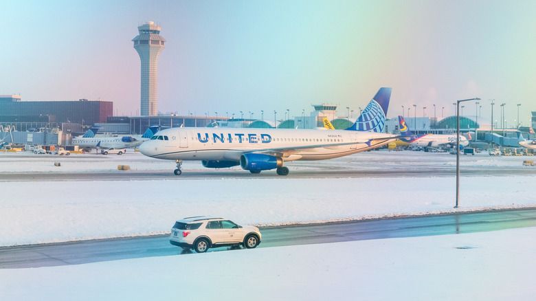 A United Airlines Airbus taxis at Chicago O'Hare International Airport while a service vehicles drives nearby