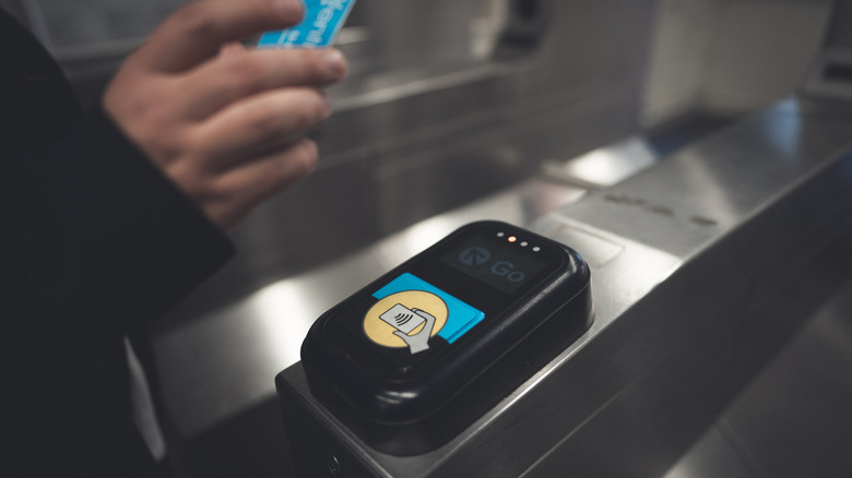 A hand scanning a Ventra public transit pass card at a Chicago terminal