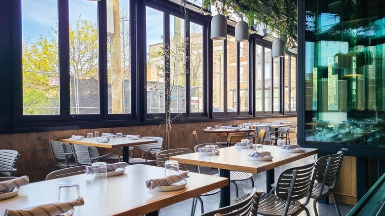Wooden tables and hanging greenery at Andros Taverna in Chicago.