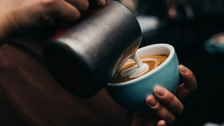 barista pouring a latte