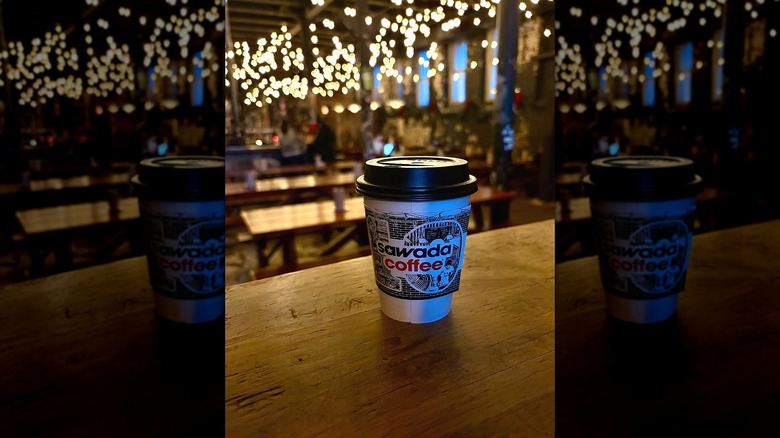 sawada coffee cup on a table with lights behind