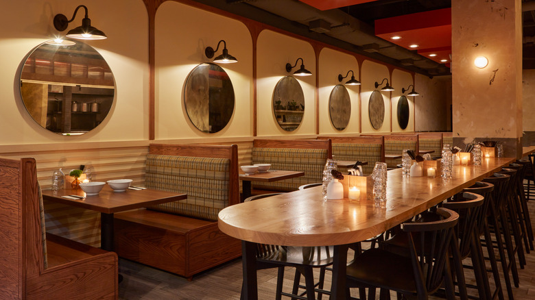 Interior image of the main booths and middle island table at Akahoshi Ramen, a ramen restaurant in Chicago.