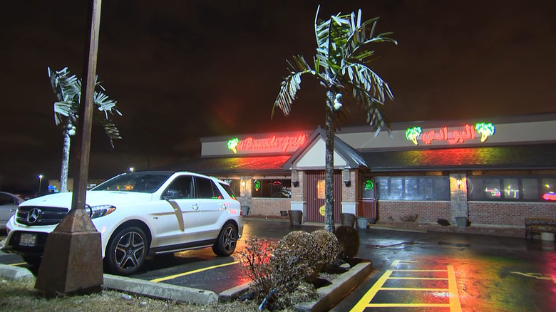 Outside of Al Bawadi Grill in Bridgeview with neon signs lit at night