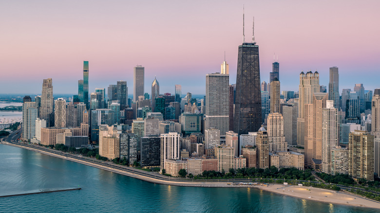 The Chicago skyline at dusk, with Lake Michigan's shoreline in the foreground