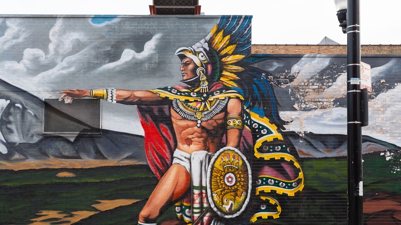 A mural of an ancient Mexican warrior painted on a building in Pilsen