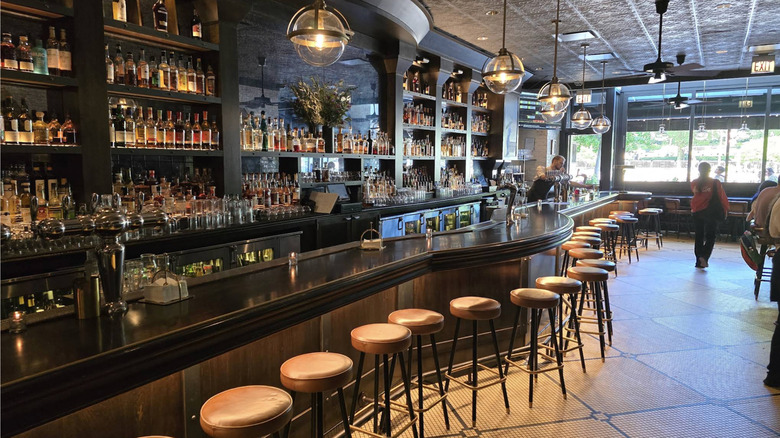 The interior of the Gage, showing a well-appointed bar and leather stools.