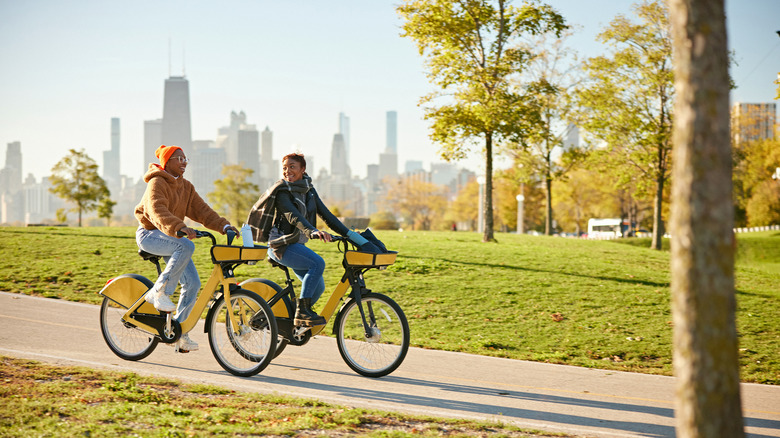 Two women cycle in park