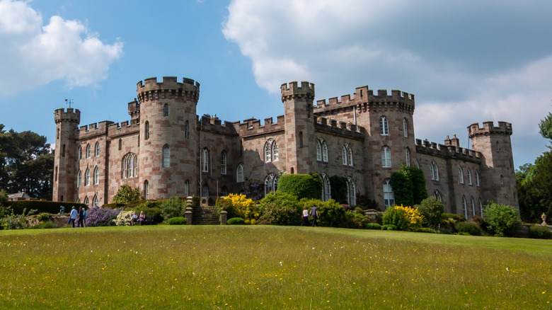 Cholmondeley Castle and surrounding gardens, trees, and foliage at Cholmondeley Castle Gardens in Cheshire, England