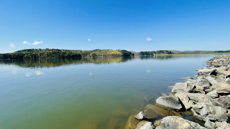 Tappan Lake's calm, clear water surrounded by rocky shores and trees on the far side