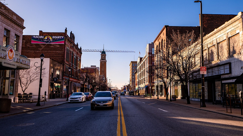car on road with buildings on side under blue sky
