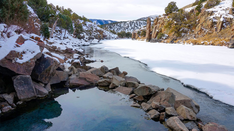 An emerald colored natural hot bath overlooking the picturesque snowy landscape of Colorado at the Radium Hot Springs