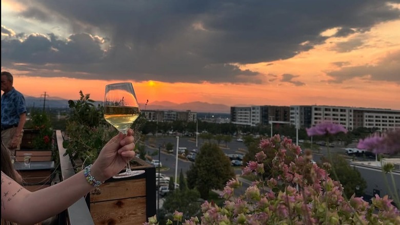 Glass of white wine with a view of mountains and city