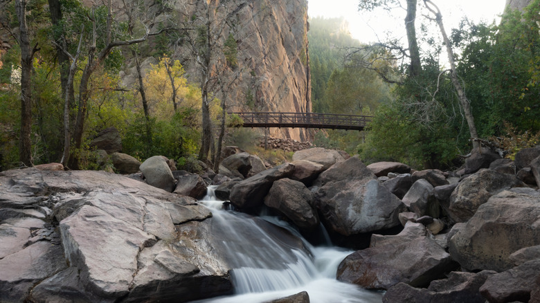 A bridge over a stream flowing over rocks in Eldorado Canyon State Park
