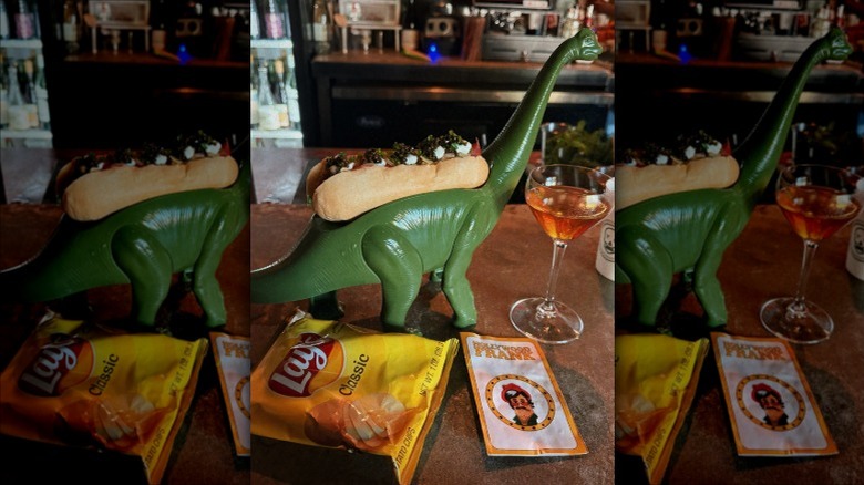 A hot dog on a dinosaur holder