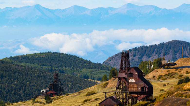 Historic mining equipment against the backdrop of mountains