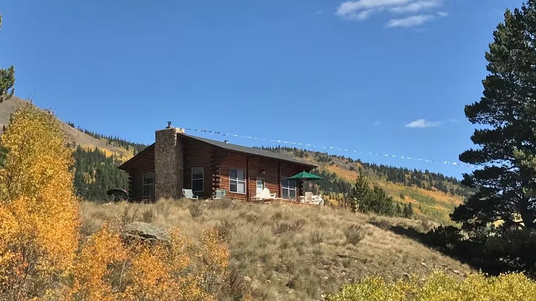 The exterior of a cabin in Como, Colorado, perched on a hill