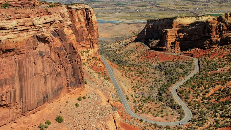 View of winding Rim Rock Drive between red rock cliffs