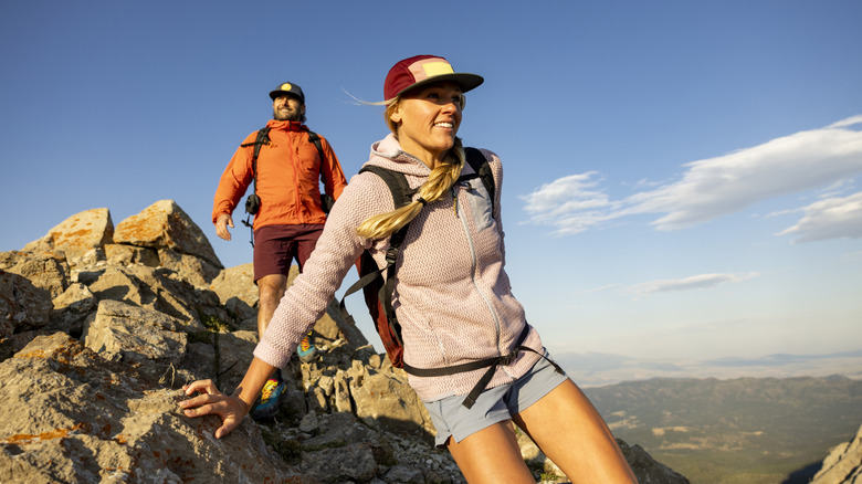 Two hikers climbing over rocks