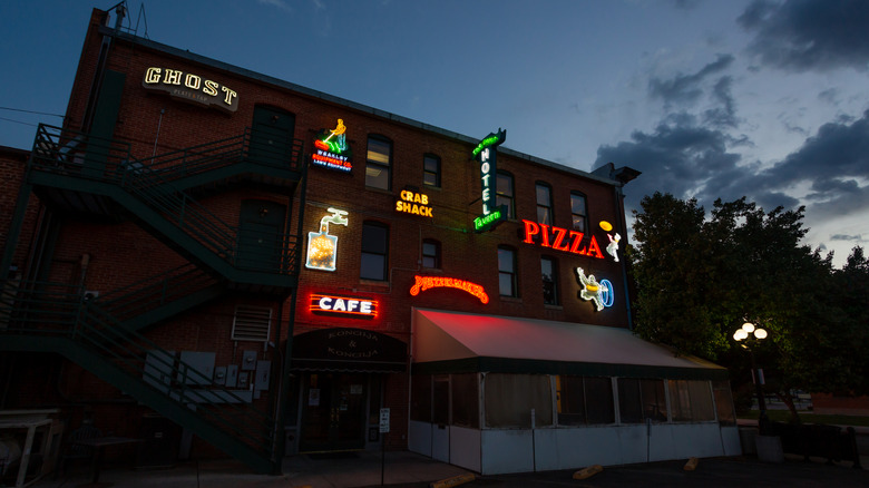 Vintage neon signs light up the side of a building in Pueblo, Colorado