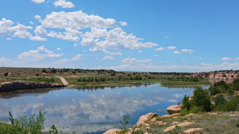 Two Buttes Reservoir with water and clouds reflected in it on sunny day