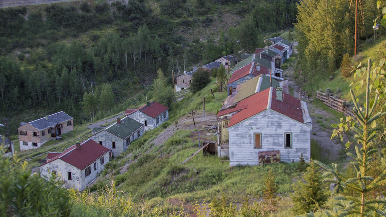 A view overlooking abandoned houses on the grassy slopes of Gilman, Colorado