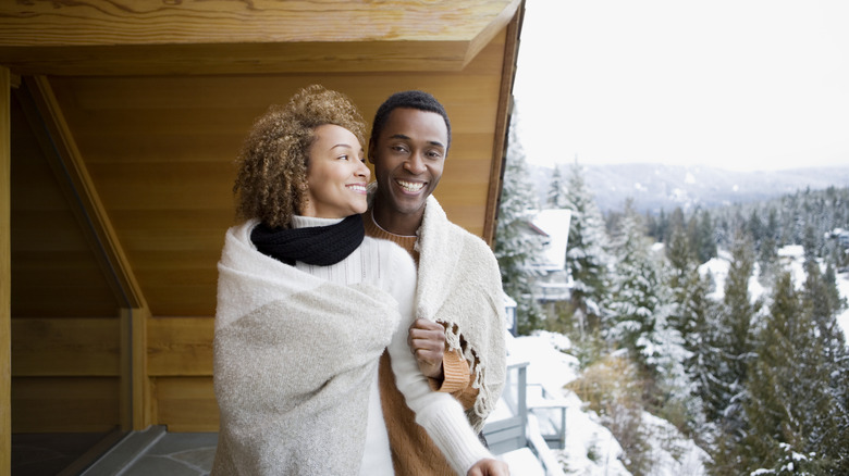 Couple wrapped in a blanket on balcony