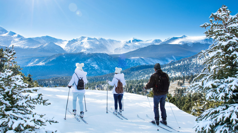 Family of skiers gaze at Rocky Mountains