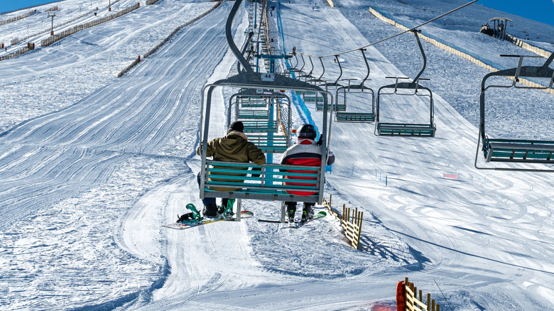 Skier and snowboarder ride chairlift