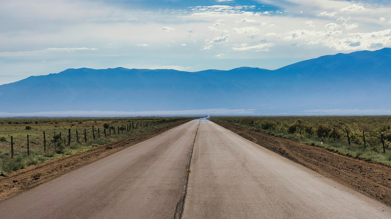 Empty road leading into hazy mountains, San Luis Valley, Colorado