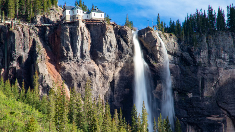 Bridal Veil Falls waterfall on sunny day with historic building at top