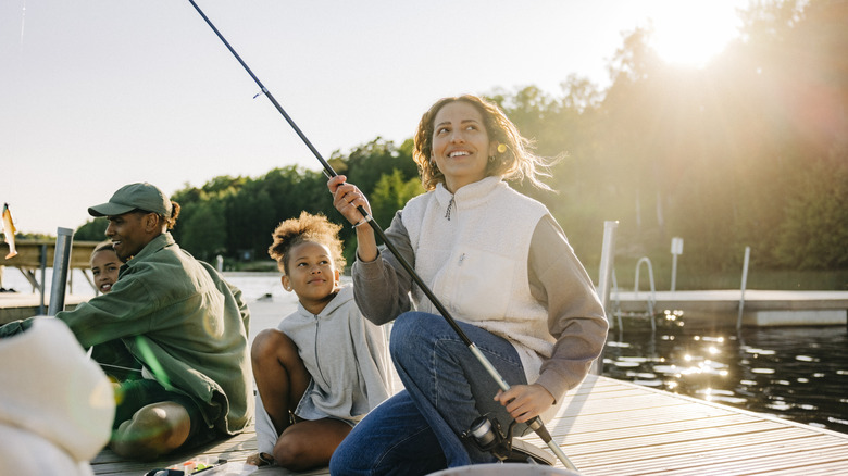 Family with children fishing on pier