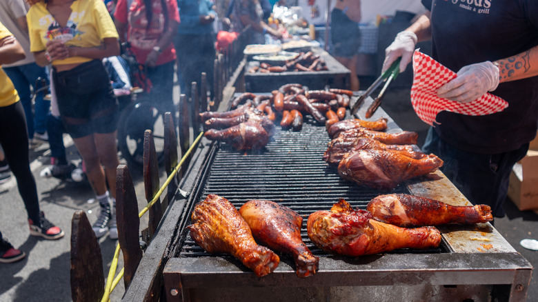 Giant turkey legs and sausages being cooked on an outdoor grill at the Juneteenth festivities in Five Points, Colorado