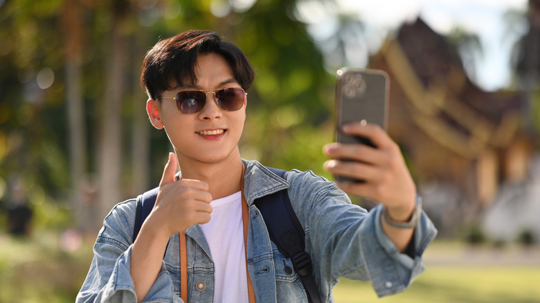 Man in denim shirt in hot weather taking photo