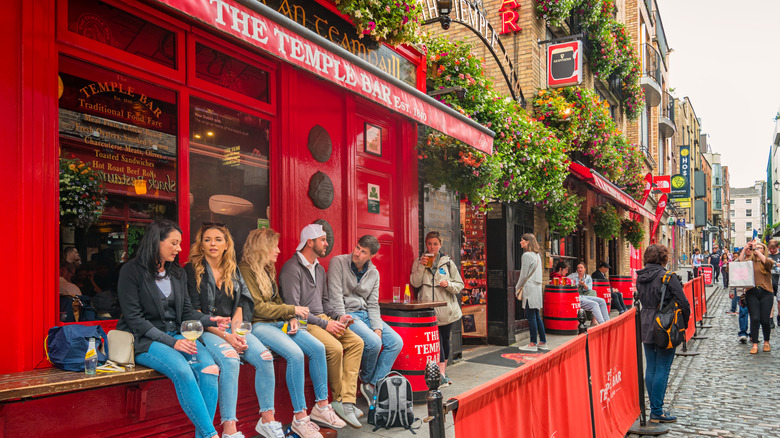 People relax at the landmark Temple Bar pub in downtown Dublin, Ireland on a cloudy afternoon