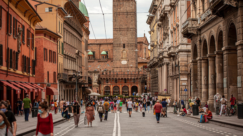 Old street with lots of people walking in Bologna, Italy