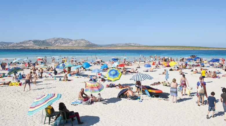 People sitting on a sandy beach in Italy