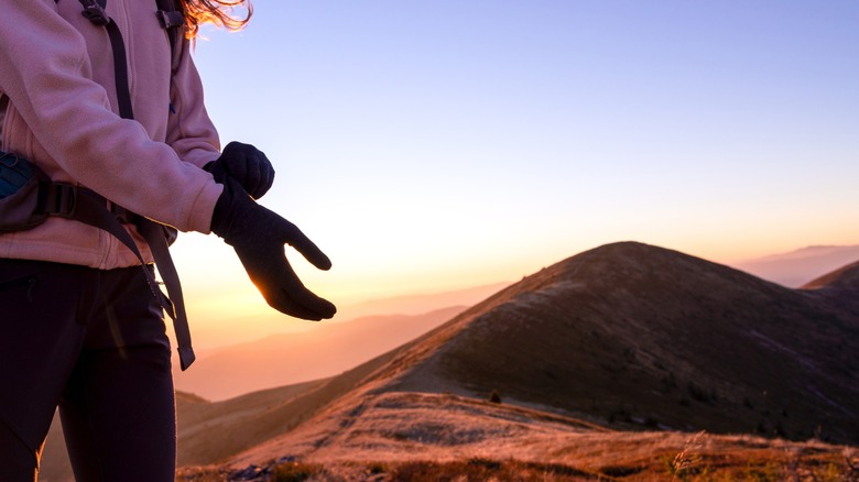 A woman wearing gloves while hiking