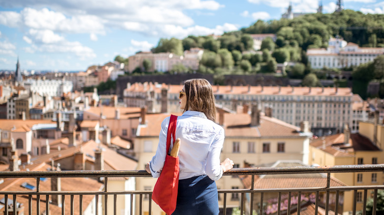 Young woman with red bag enjoying great view on Lyon city in France