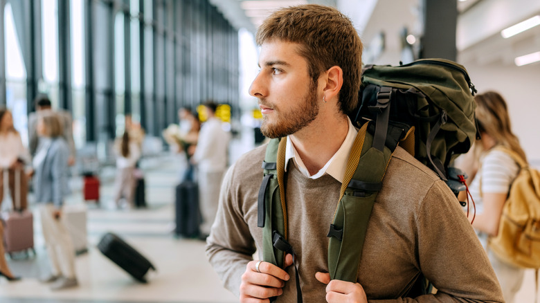 image of young man traveling, standing in airport