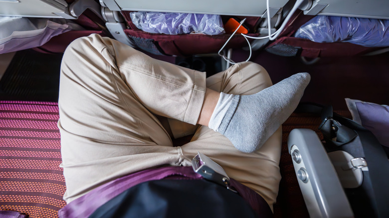 A passenger sitting cross-legged on a flight