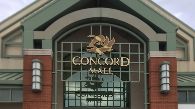 Metal and brick facade of Concord Mall with a sign