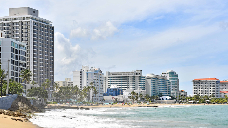 high-rise hotels and condominiums tower over a golden-sand beach