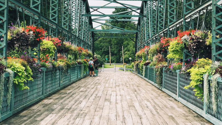 Visitors walk over the Drake Hill Flower Bridge in Simsbury, Connecticut