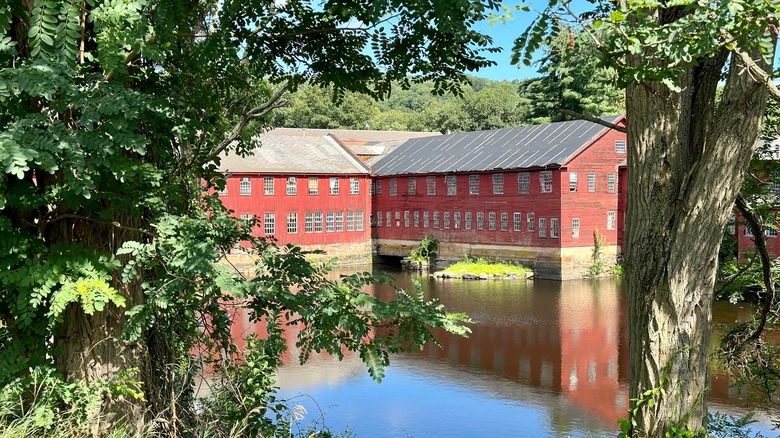 A historic red building on the banks of the Farmington River in Collinsville, Connecticut