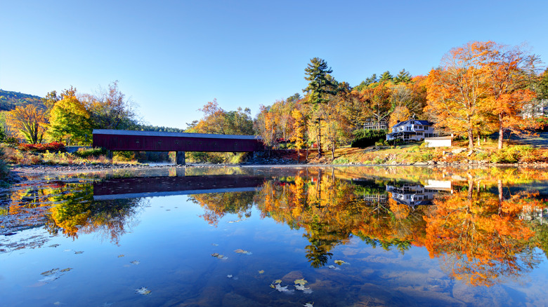 A bridge, river, house, and autumn foliage in West Cornwall, CT
