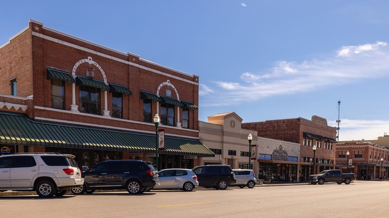 Cars parked outside historic brick buildings and shopfronts in Downtown Conroe.
