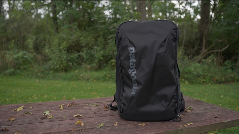 Patagonia Black Hole Mini MLC on a picnic table, with trees in the background